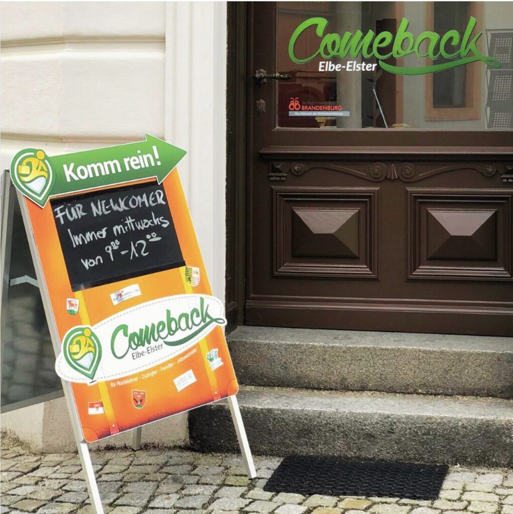 Vor dem Eingang des Comeback-Büros in Finsterwalde steht auf Aufsteller mit einer Veranstaltungsankündigung