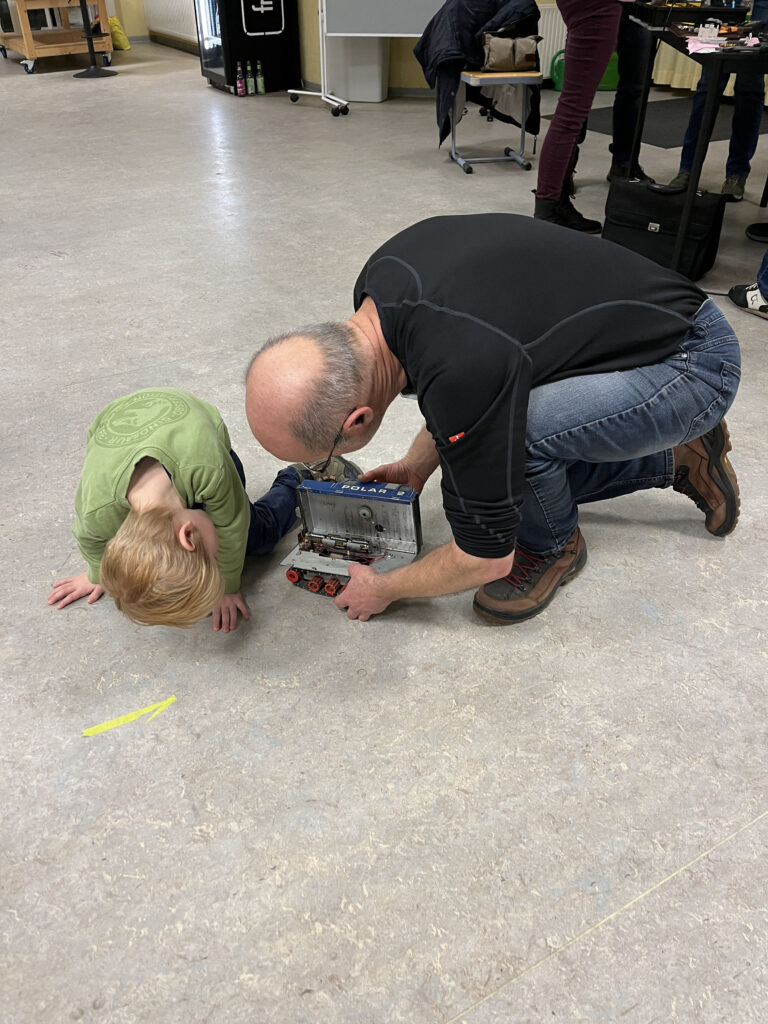 Ein Mann und ein Junge inspizieren ein Modellauto