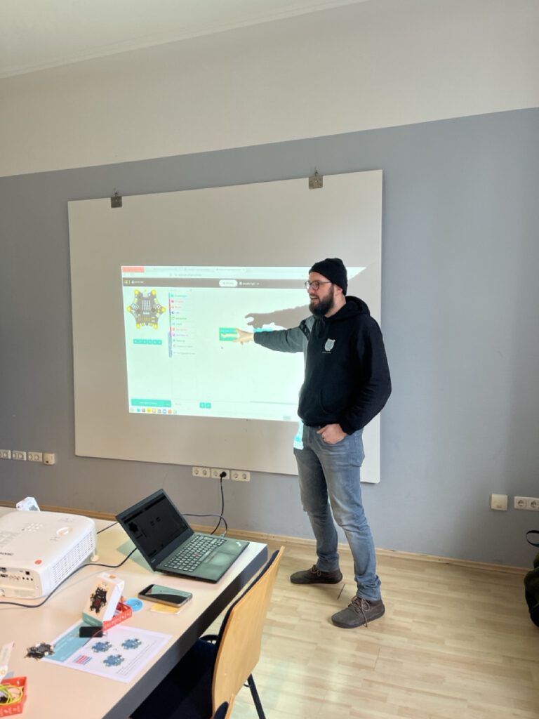 Max Paulus steht vor der Projektion der Präsentation der Programmierschritte